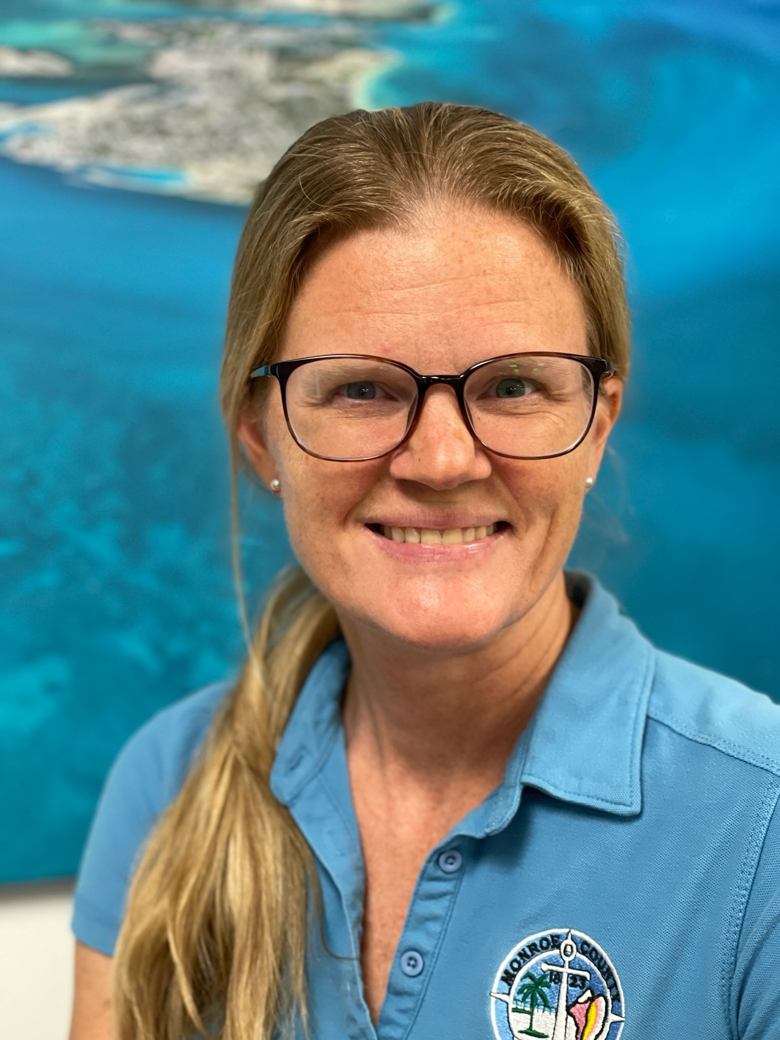 Emily Schemper headshot in front of blue map